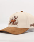 Beige and brown suede cap with deer design and text on a white background