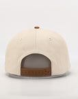 Beige cap with brown leather strap on a light gray background