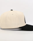 Beige and black baseball cap on a white background