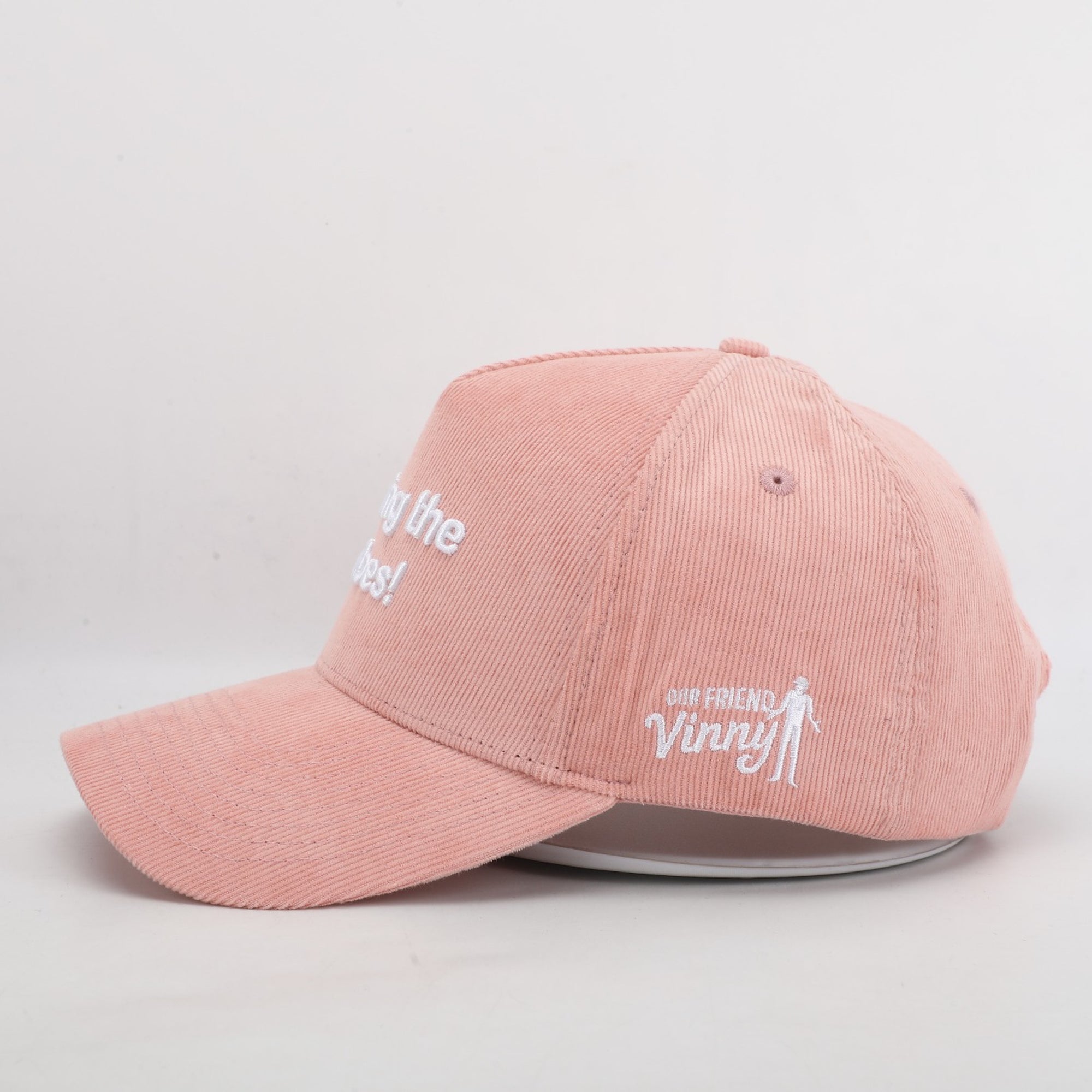 Pink cap with white text and graphics on a light gray background