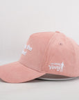 Pink cap with white text and graphics on a light gray background