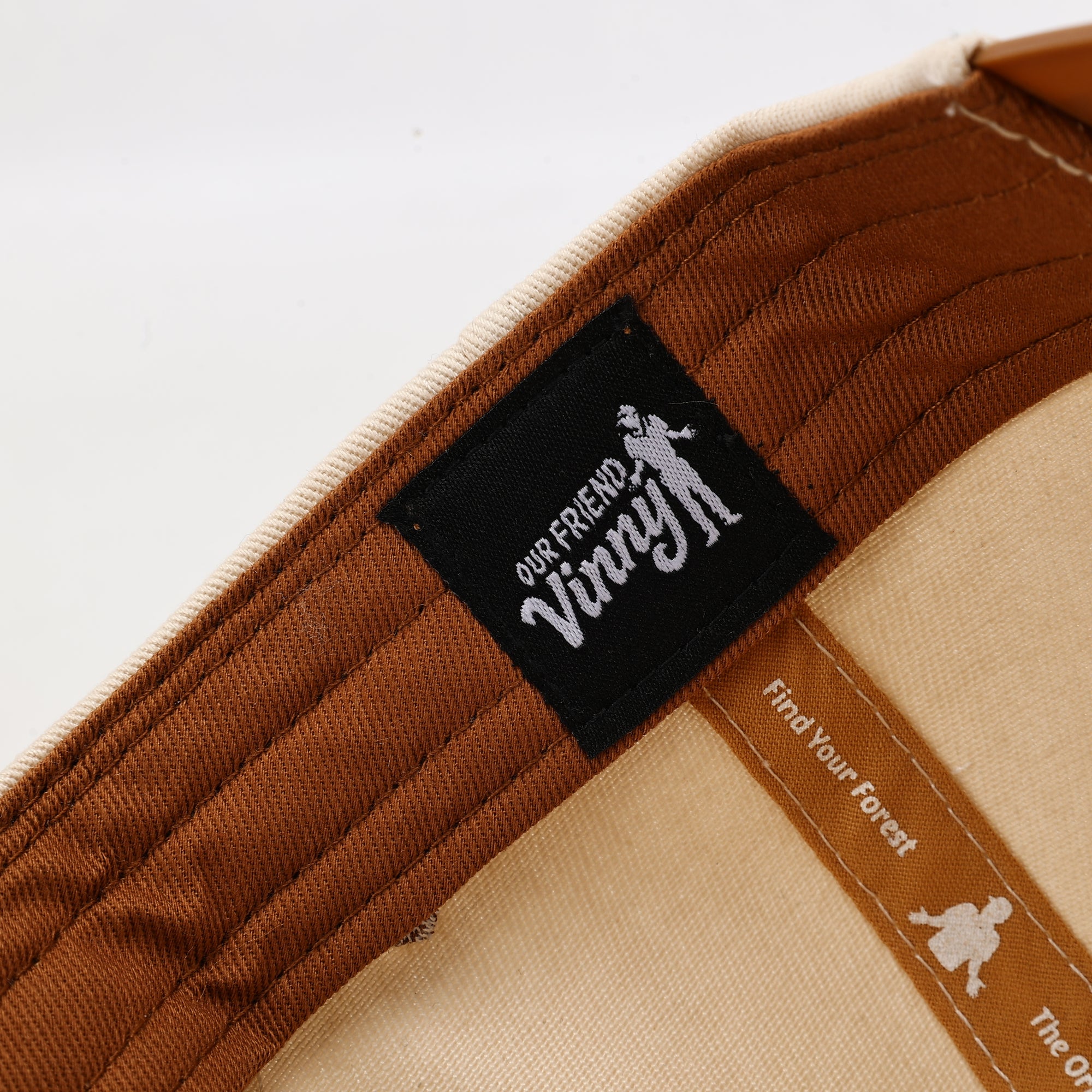 Close-up of a brown product with a black label featuring 'Our Friend Vinny' on a white background.
