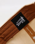 Close-up of a brown product with a black label featuring 'Our Friend Vinny' on a white background.