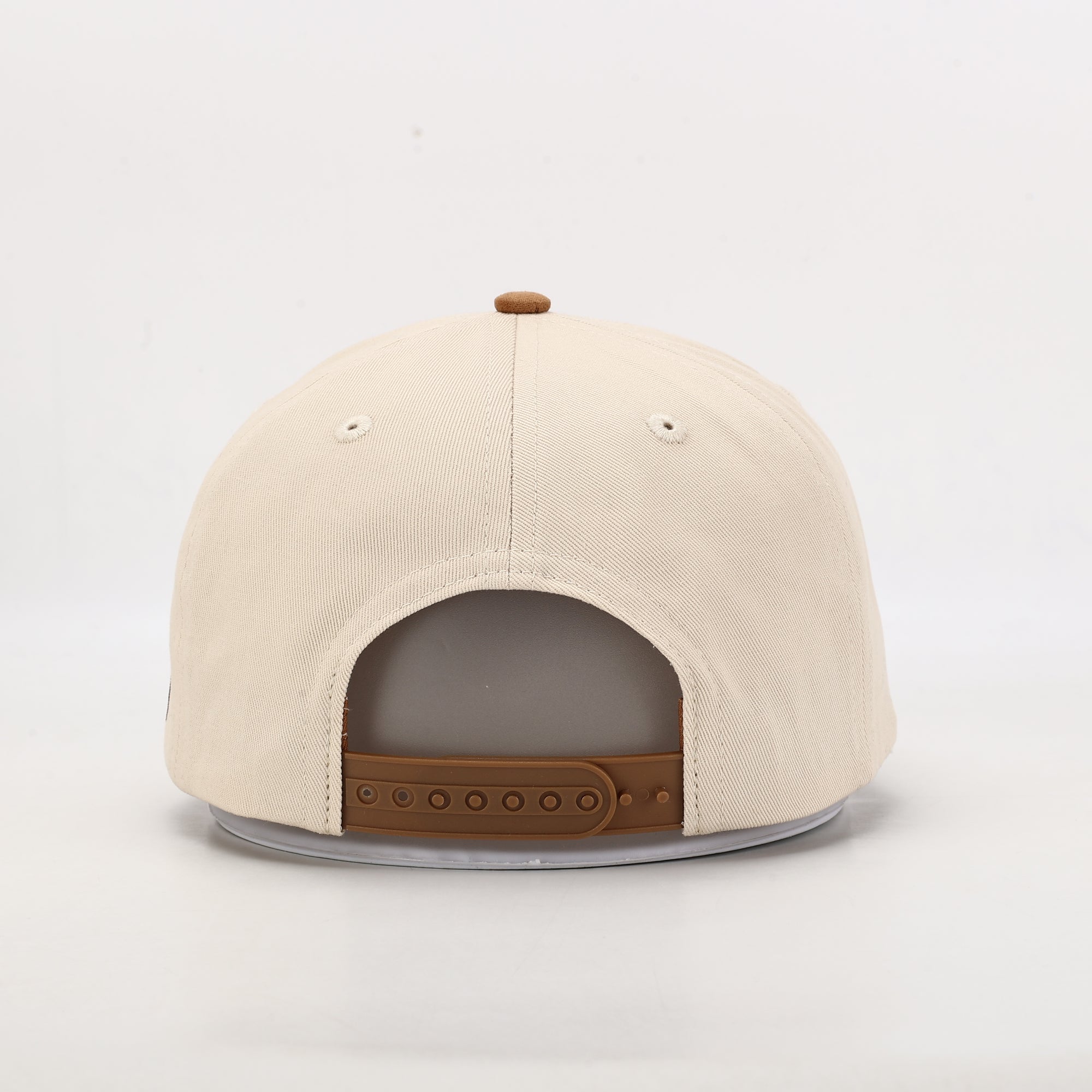 Beige cap with brown leather strap on a light gray background
