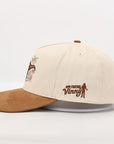 Beige and brown cap with embroidered design on a white background