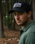 Man wearing a cap with text in a forest setting
