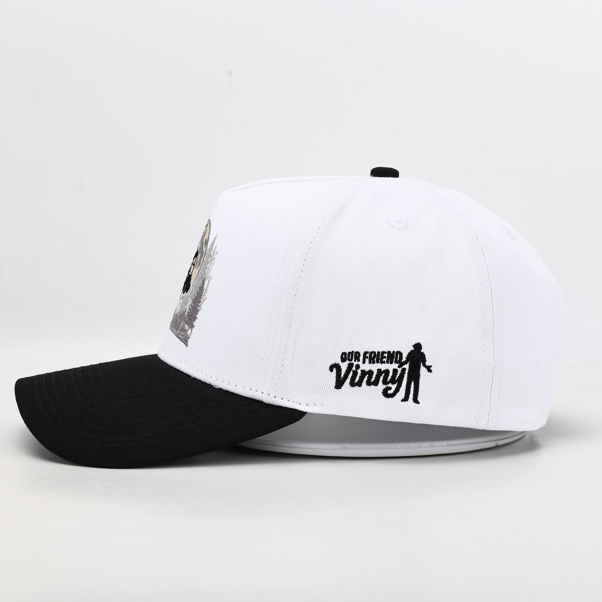 White and black cap with 'Our Friend Vinny' text and logo on a white background