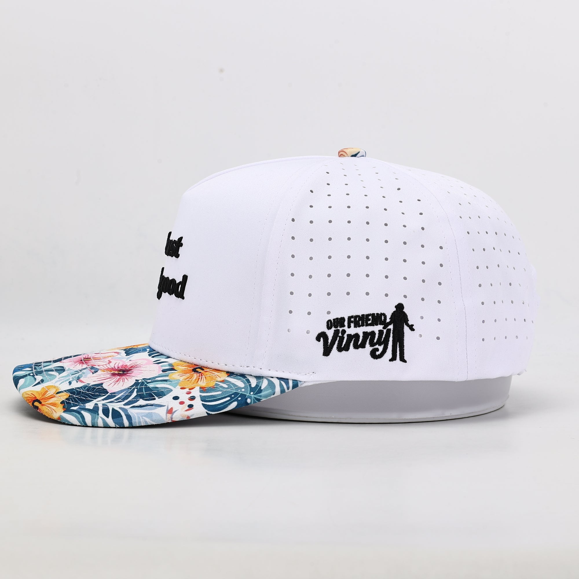 White cap with floral brim and black text on a light gray background
