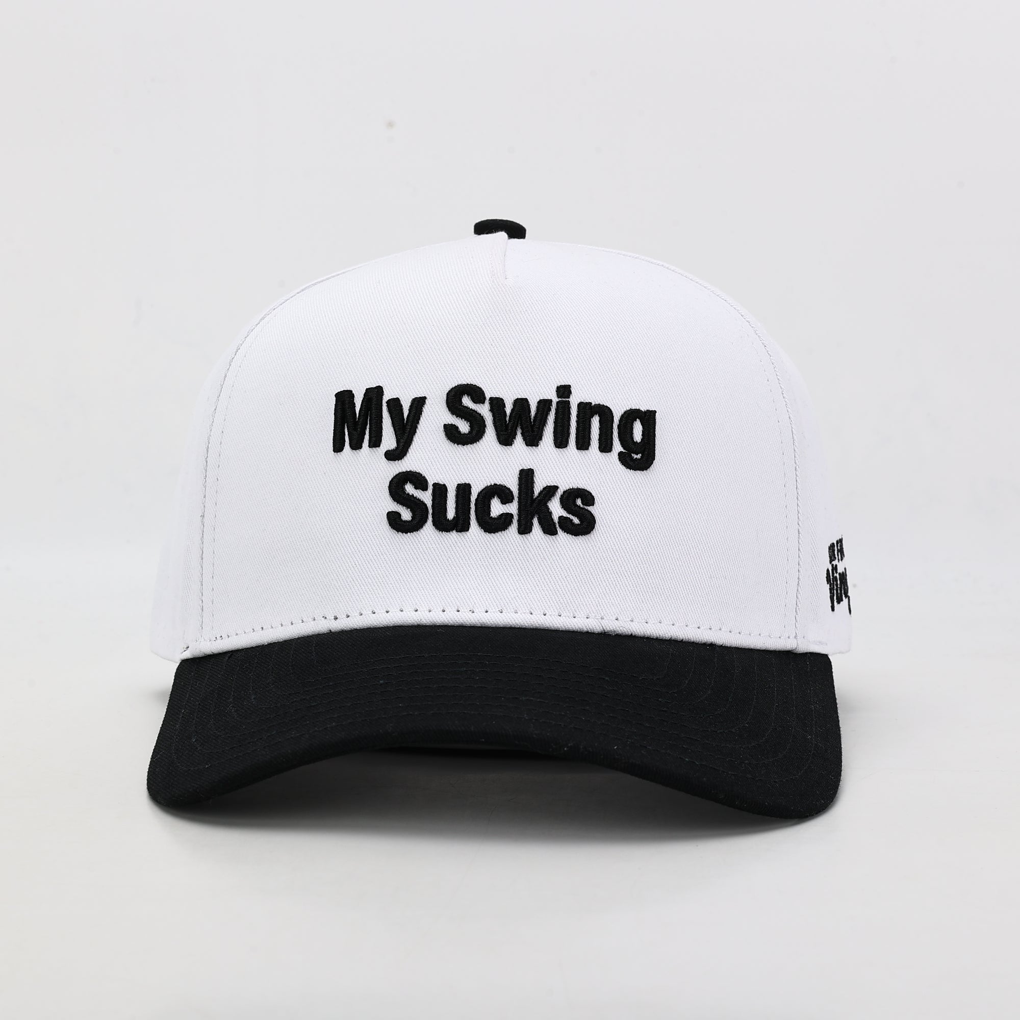 White cap with black text 'My Swing Sucks' on a light gray background