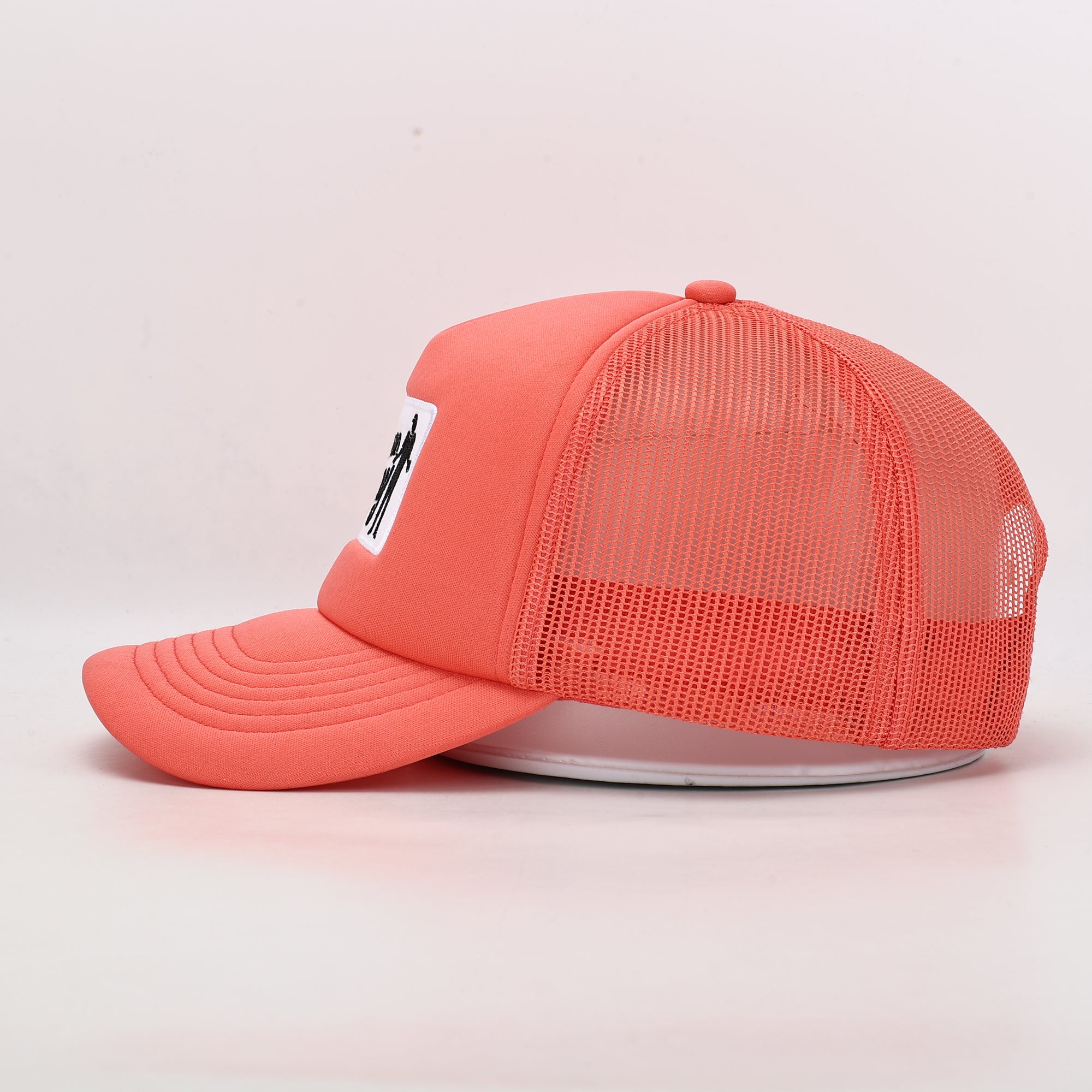 Coral pink trucker cap with mesh design and white logo 