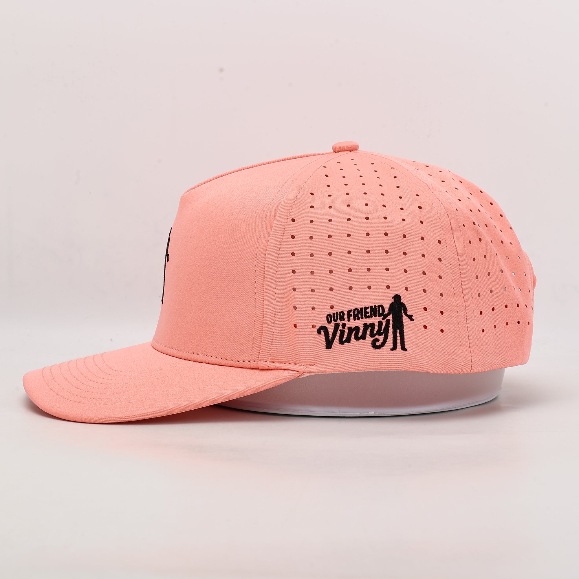 Peach cap with 'Our Friend Vinny' logo on a light gray background