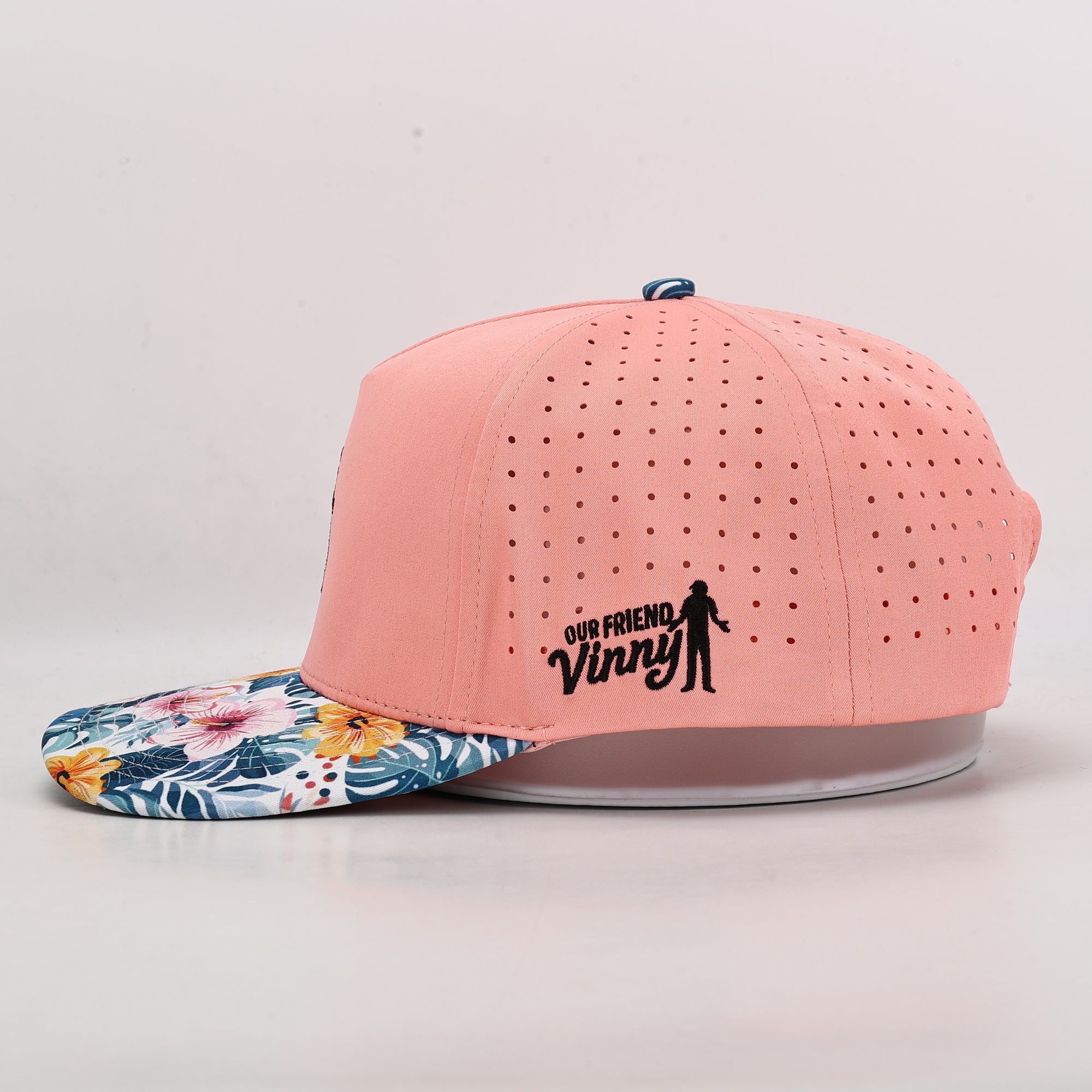 Ventilated Pink cap with floral brim and 'Our Friend Vinny' text on a light gray background