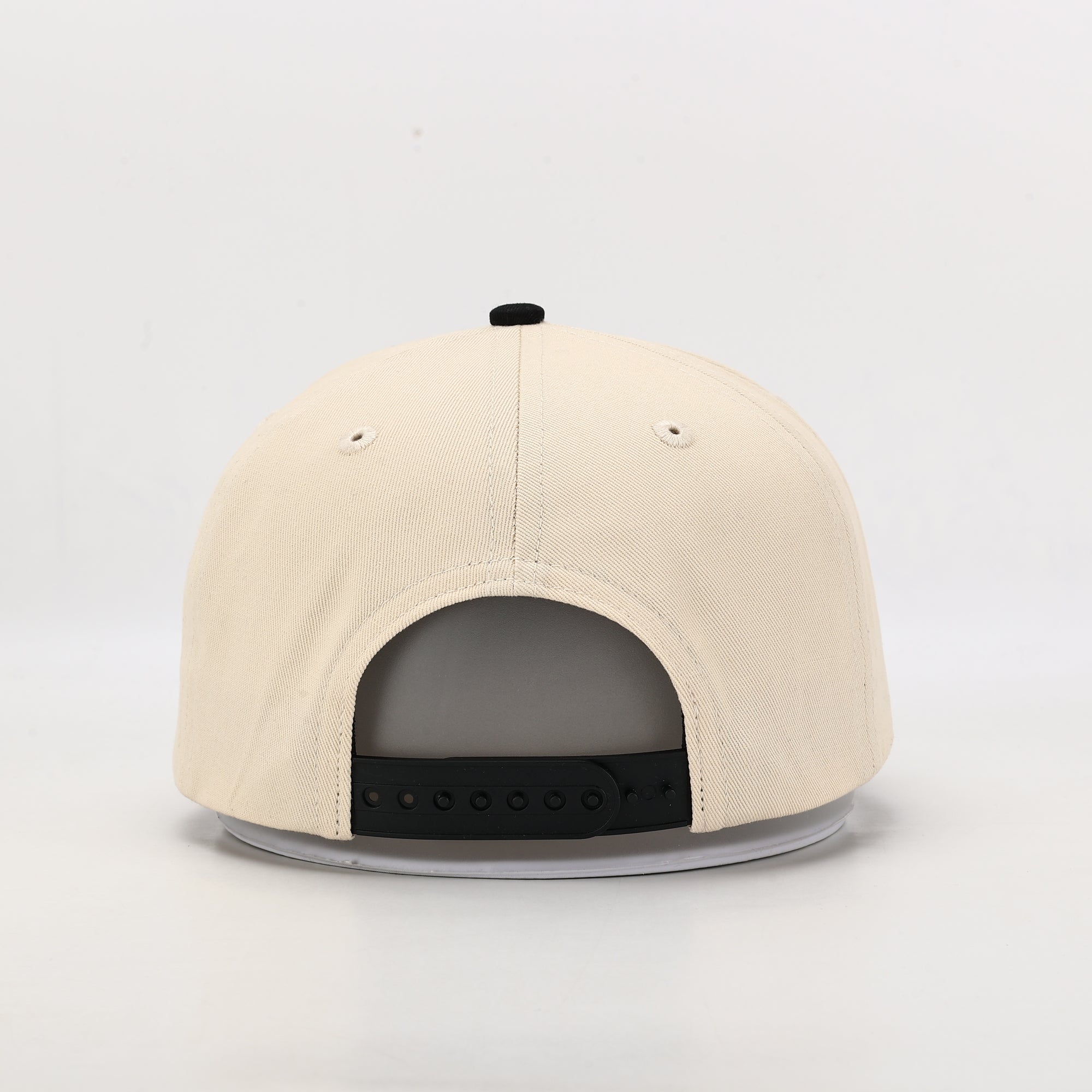 Beige cap with a black bill on a light gray background