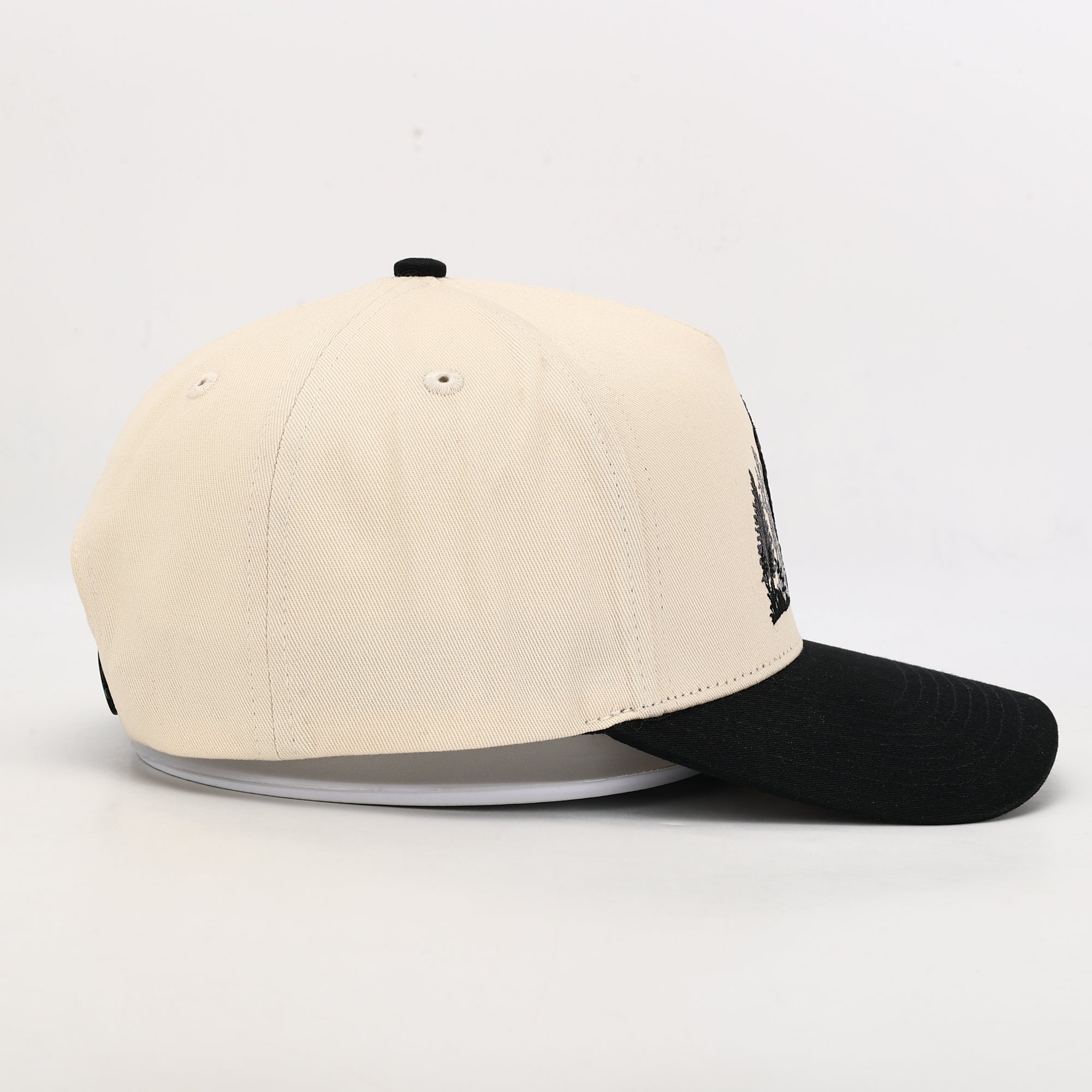 Beige and black baseball cap on a white background