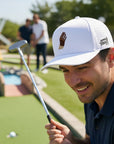 Man playing mini golf with a white cap and blue shirt