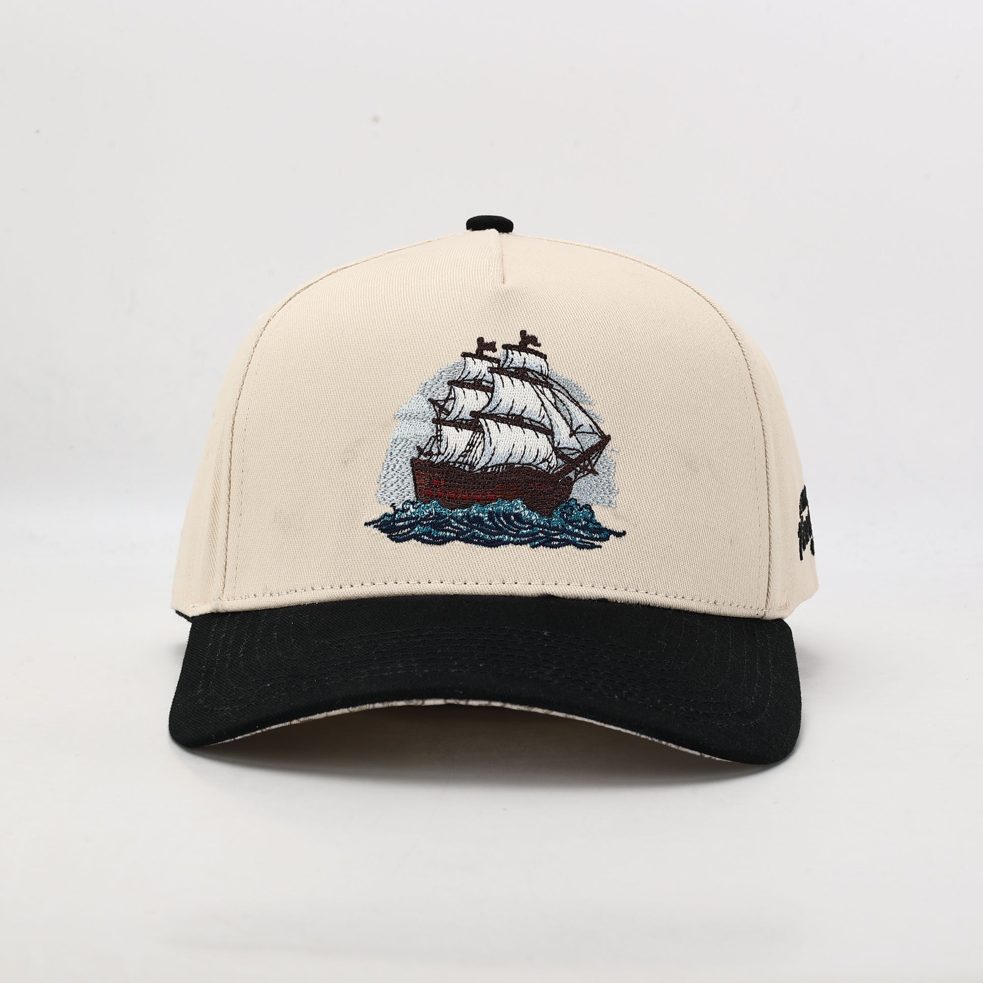 Beige Cap with embroidered ship design on a white background