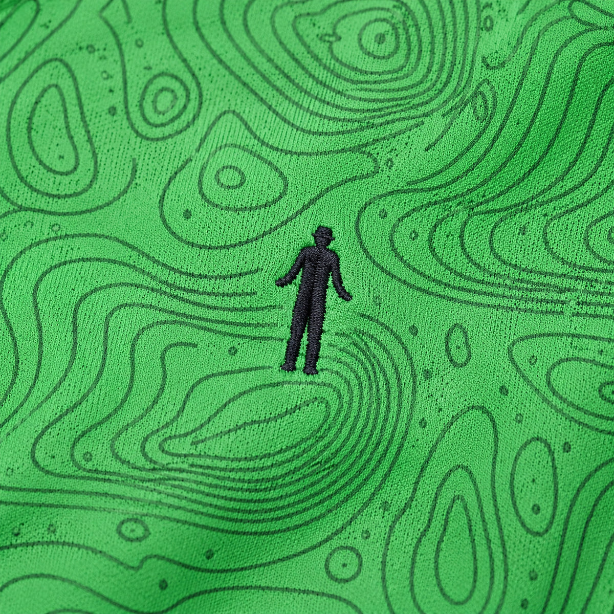 Close-up of the topographic map print and embroidered golfer logo on the Green Golf Topography Map golf polo
