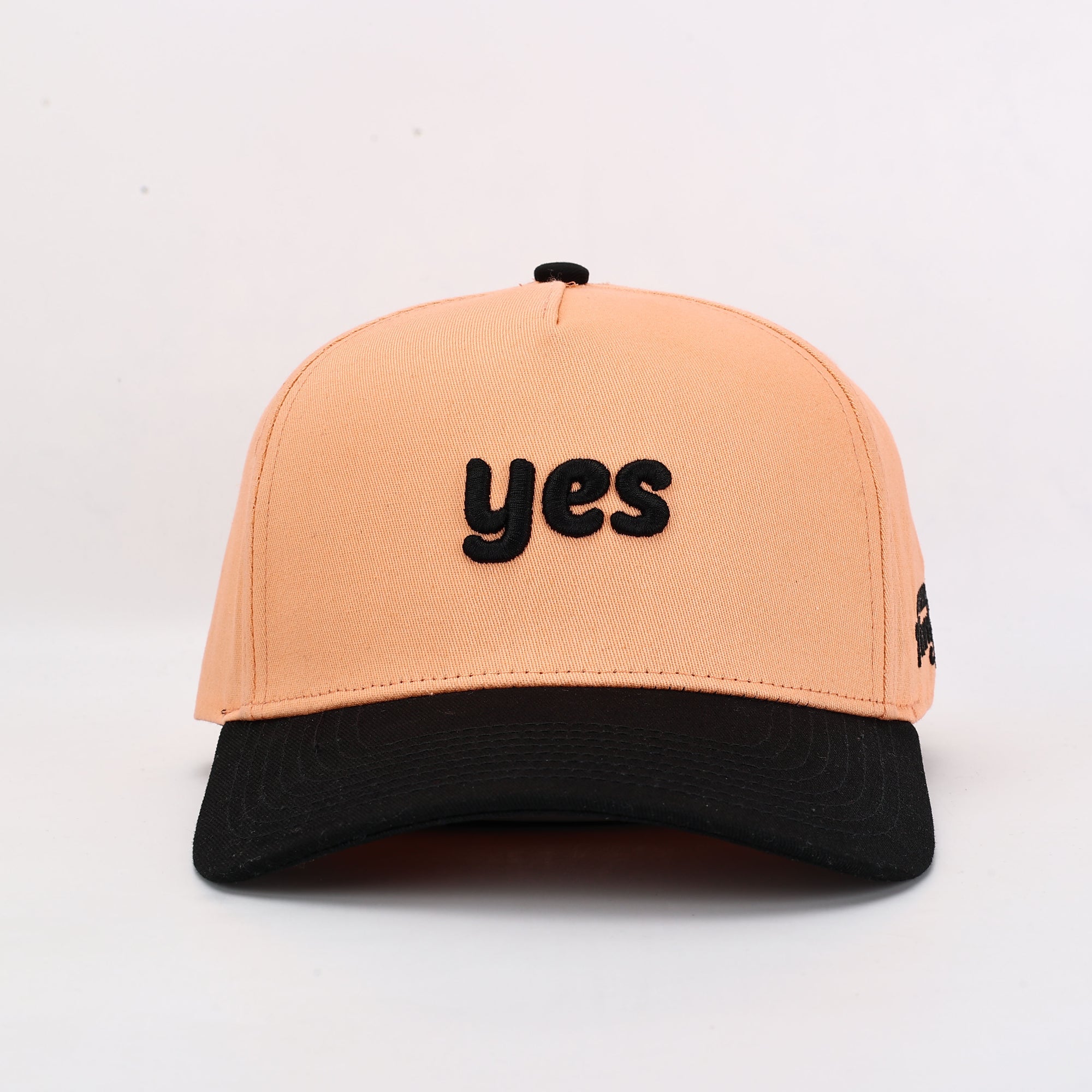 Beige cap with 'yes' text on a white background