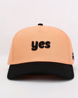 Beige cap with 'yes' text on a white background
