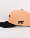 Two-tone peach and black cap with 'Our Friend Vinny' text on a light gray background